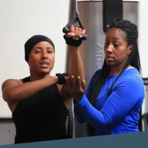 Female trainer spotting a woman's weight training form
