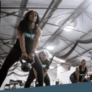 Women doing kettle bell squats in a sports dome